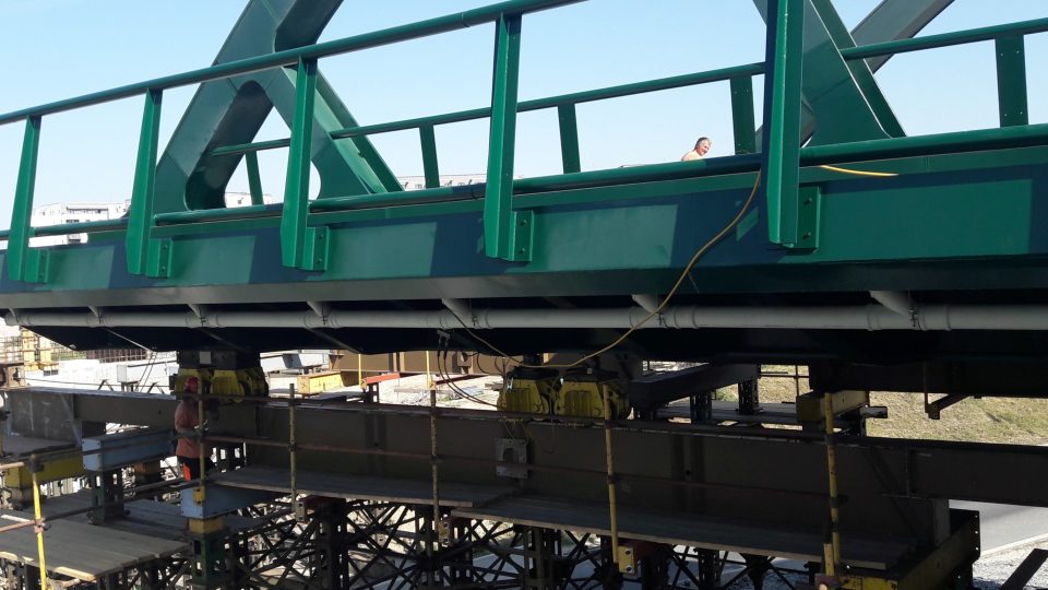 38 metrů dlouhý a 350 tun těžký je nový most tramvajové trati na plzeňská Borská pole. Už druhý den ho stavbaři posouvají do konečné polohy nad silnici 1/27