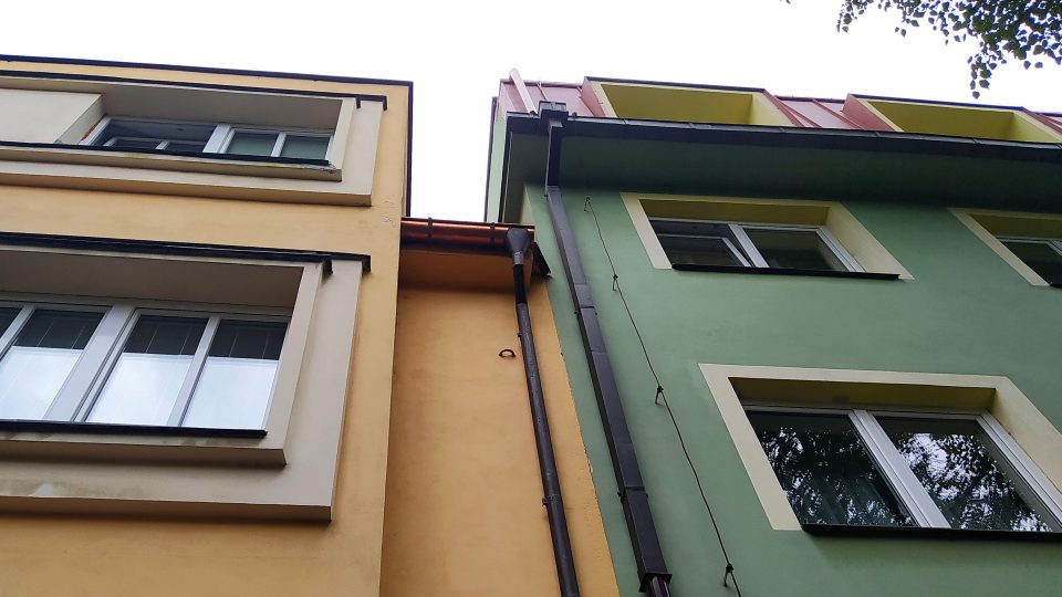 Málokdo si všimne kovových obloučků na fasádách některých domů