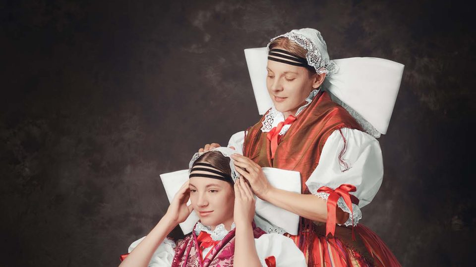 Matka s dcerou v plzeňském kroji – přípravy „holubice“, kterou na hlavě nosily svobodné dívky i vdané ženy