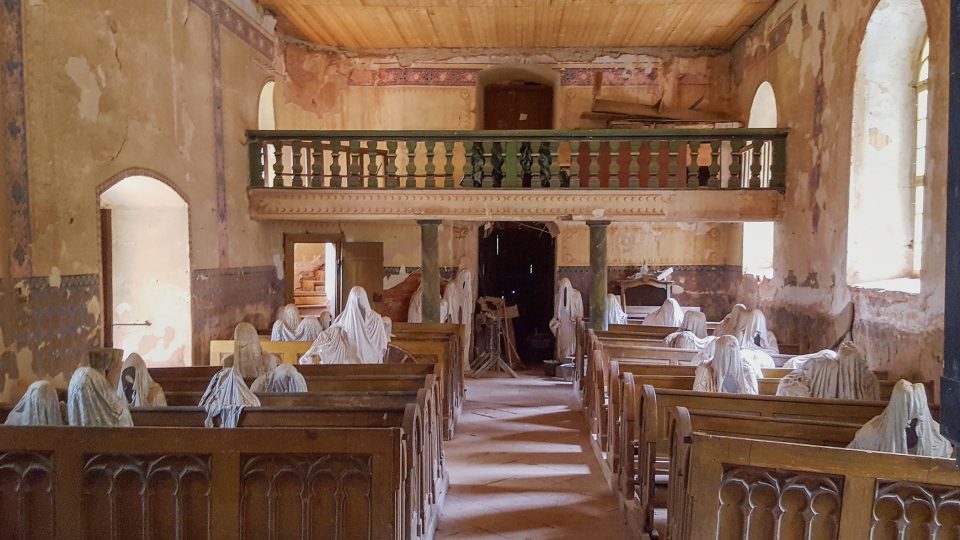 V kostele svatého Jiří v Lukově sedí v lavicích sochy duchů