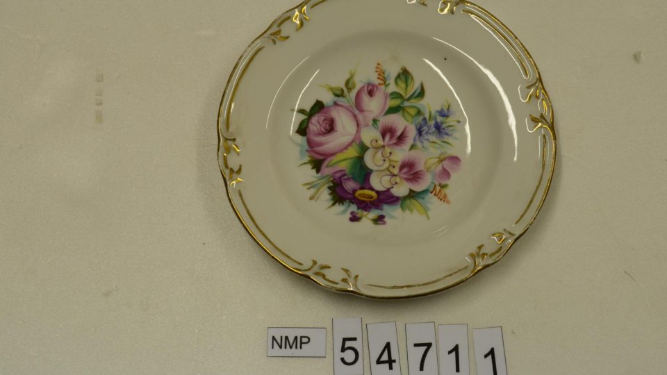 Dezertní porcelánový talíř s reliéfními rocaillovými okraji, uprostřed s pestrou malbou květů. Značka CARLSBAD