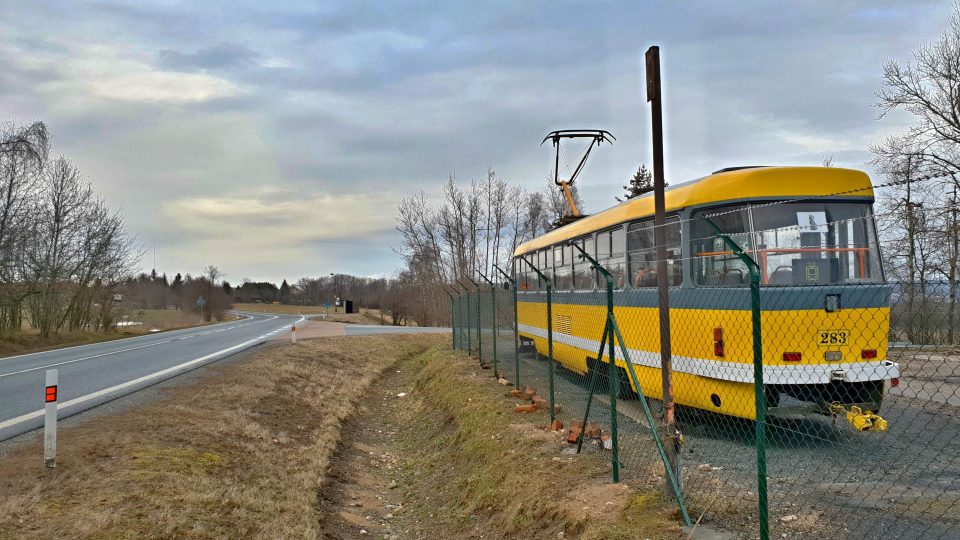 K vesnici Trhomné 30 kilometrů od Plzně sice nevedou žádné koleje ani trojele, přesto tam u lesa parkuje žlutá tramvaj