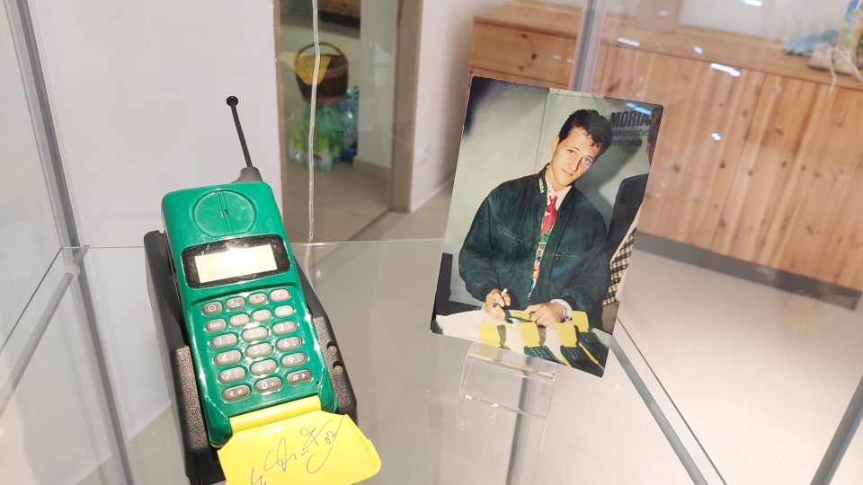 Na výstavě je k vidění i zelenožlutý telefon podepsaný od závodníka Michaela Schumachera, kterých je na světě pouze pět