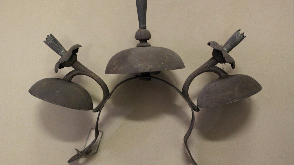 Soustava třech zvonků, každý se stejným počtem paliček, z tepané mosazi zasazená souběžně v obloukové žerdi