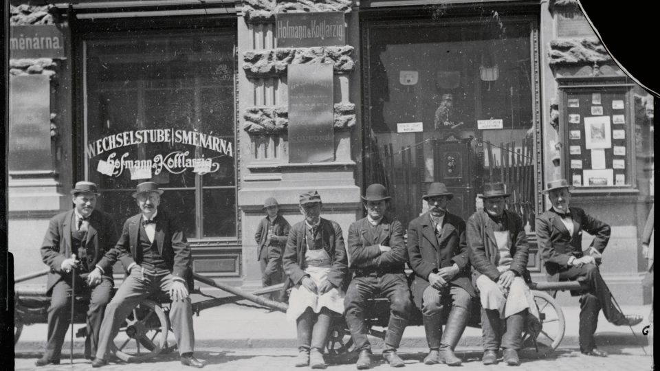 Muži sedící před obchodem J. Kleissla na rohu Sedláčkovy a Říšské (dnes Prešovské ulice) 1895