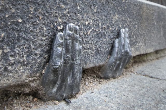 Dvě tajemné kovové ruce,  které jakoby vylézají ze škvíry pod obrubníkem u plzeňské katedrály svatého Bartoloměje,  budí zájem turistů i místních lidí. Oficiálně nikdo neví,  kdo je tam na konci minulého roku dal,  nebo zda mají nějaký hlubší význam | foto: ČTK